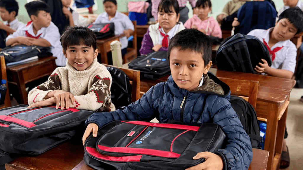 Happy students receive study gifts during Axon Active's flood relief visit