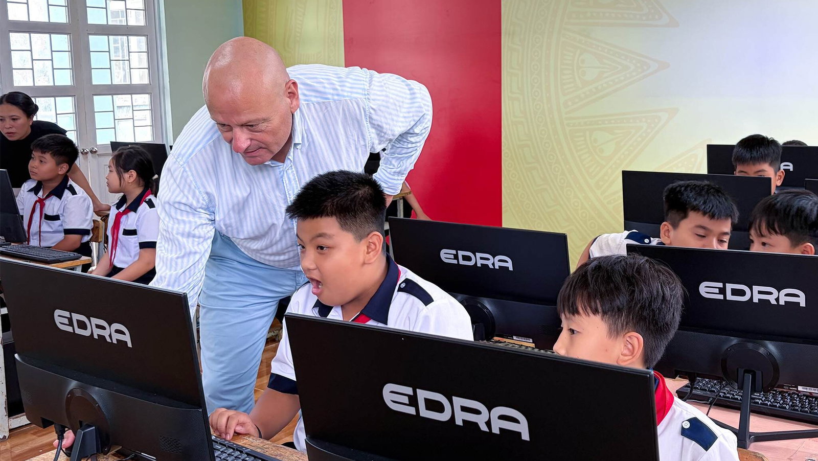 Mr. Markus Baur, CEO of Axon Active, visits students in a newly equipped computer lab.